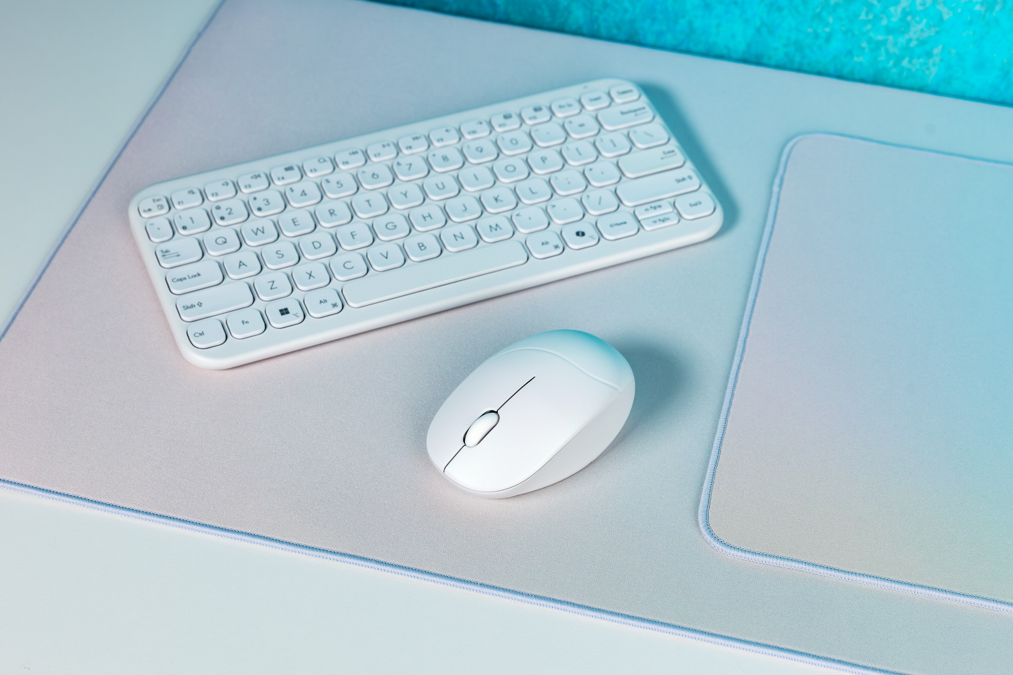 Mouse aromat ASUS Fragrance Mouse MD101 alături de tastatura ASUS Marshmallow Keyboard KW100 pe un pad ASUS PS102